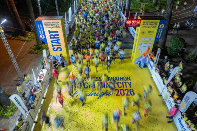Colegi de birou în tricouri colorate care participă la o întrecere de tras frânghia într-un parc