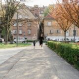 Doi prieteni care aleargă împreună pe o alee dintr-un parc, într-o dimineață de toamnă